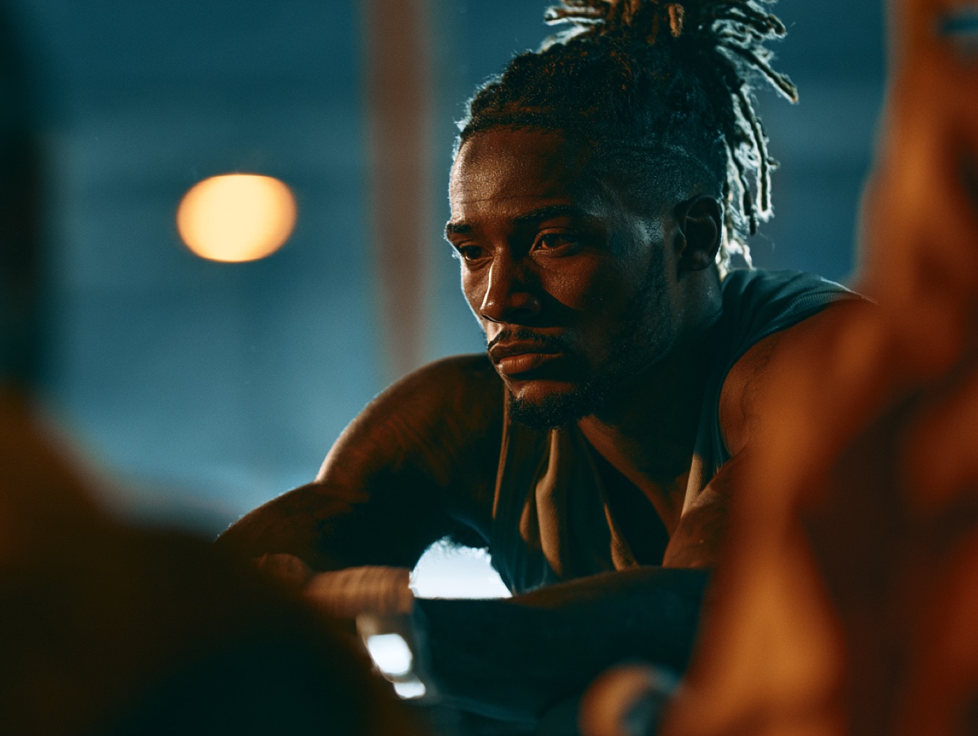 An athlete listening intently in low blue light